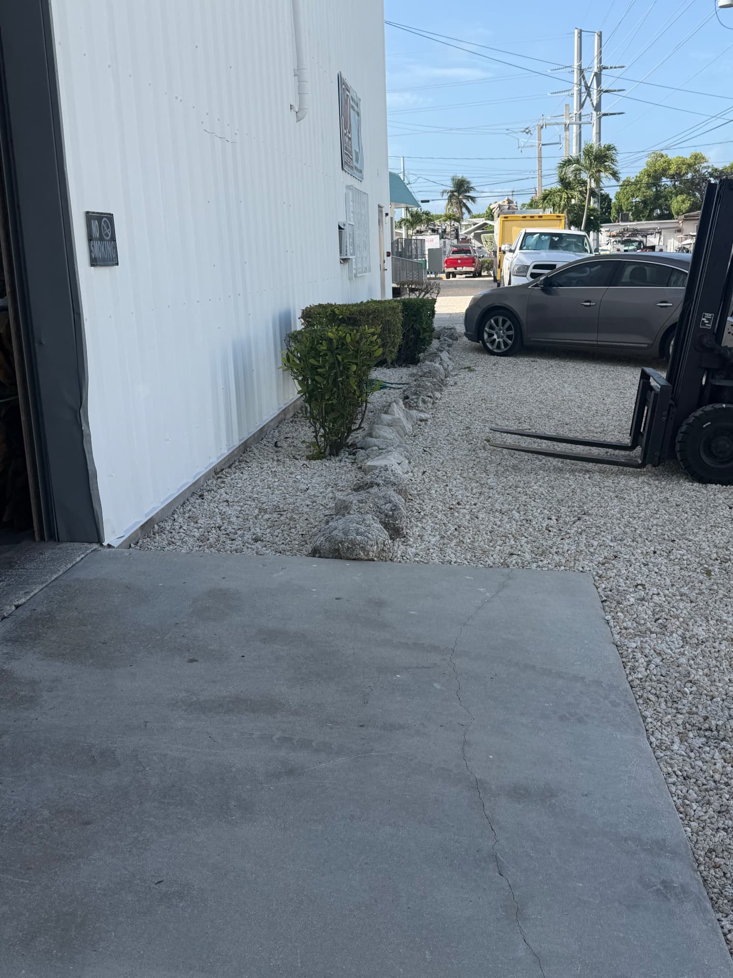 Exterior Property Care — Industrial building side hedge and gravel detail