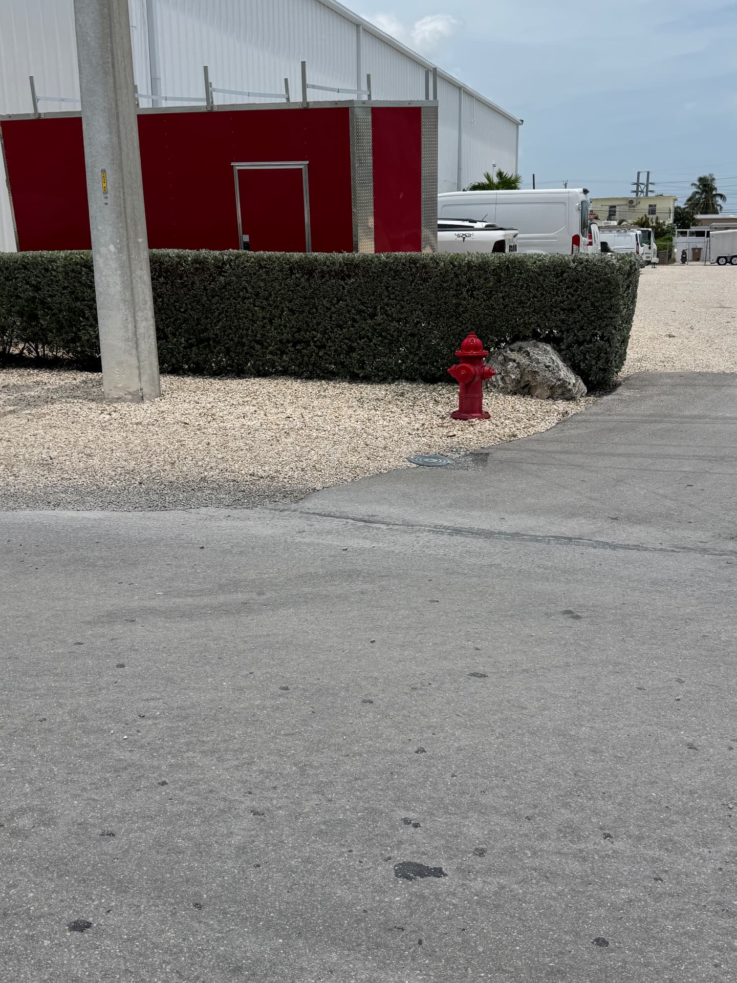 Apartment & Commercial Complex Maintenance — Industrial building hedge line and gravel landscaping